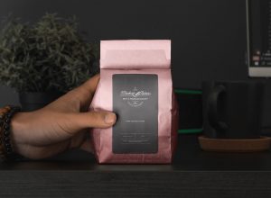 Free-Hand-Holding-Coffee-Pouch-Packaging-Mockup-Design-Template